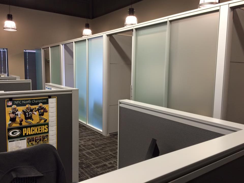 Cubicle of an office with a calendar poster of Packers NFC North Champions