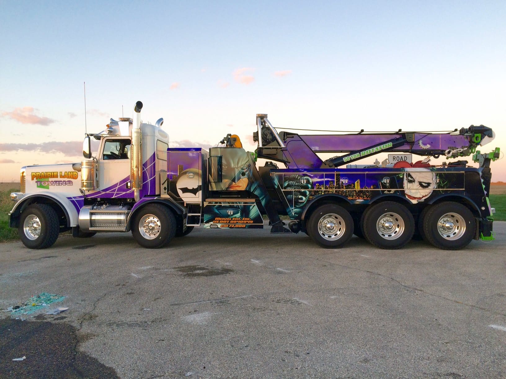 Company towing truck with purple vehicle wrap featuring a DC comic design to promote a fun and exciting business