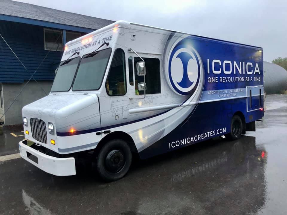 Iconica construction company truck with dark blue and white Fleet Graphics Vehicle wrap designed by Madison Graphics Company parked in a rainy lot