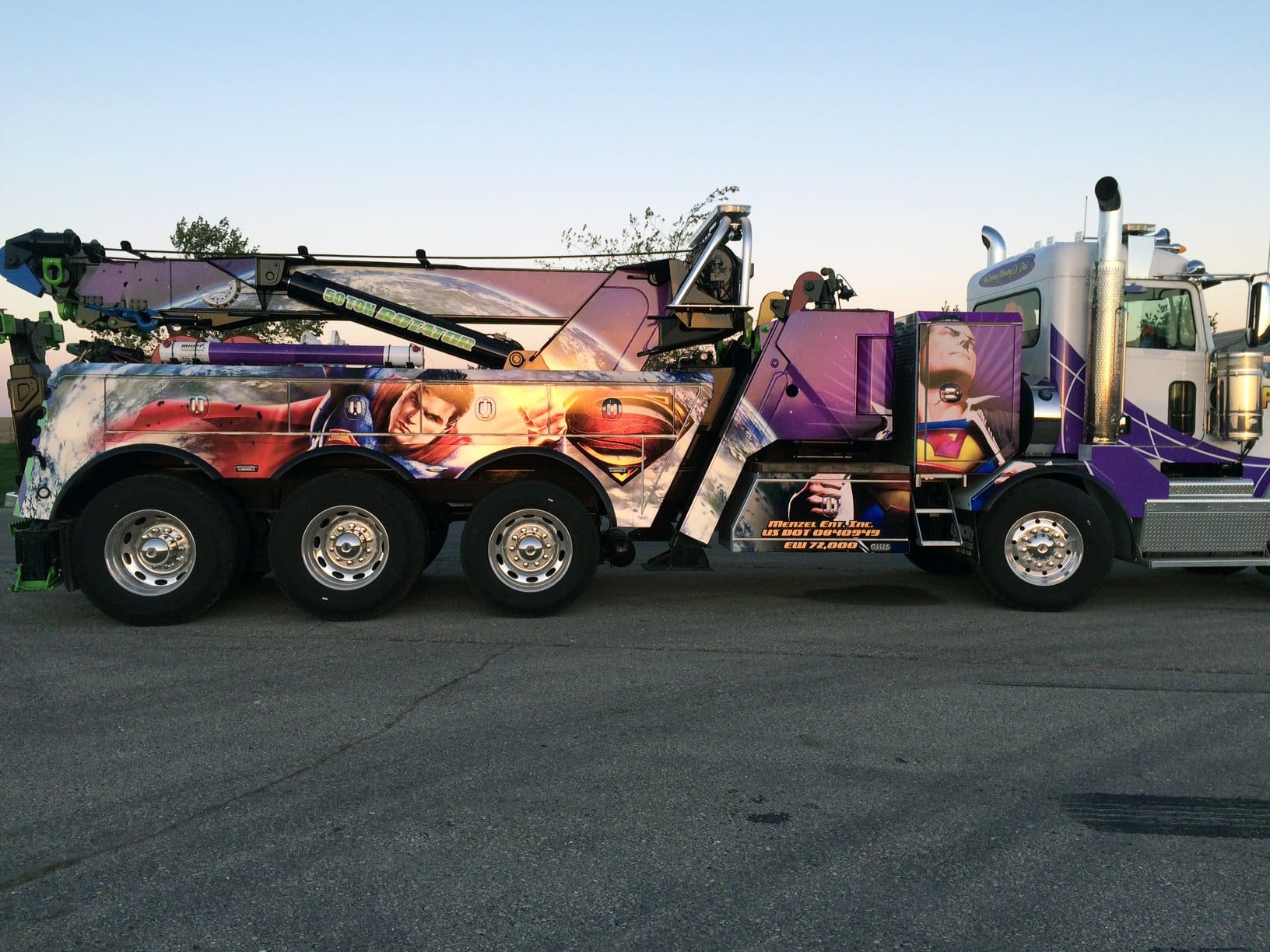 Company towing truck with purple vehicle wrap featuring a DC comic superman design to promote a fun and exciting business