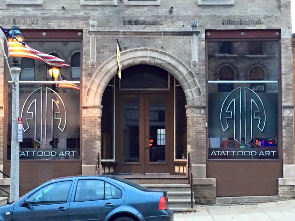 Glass film banner on the side of a building promoting Atattood Art
