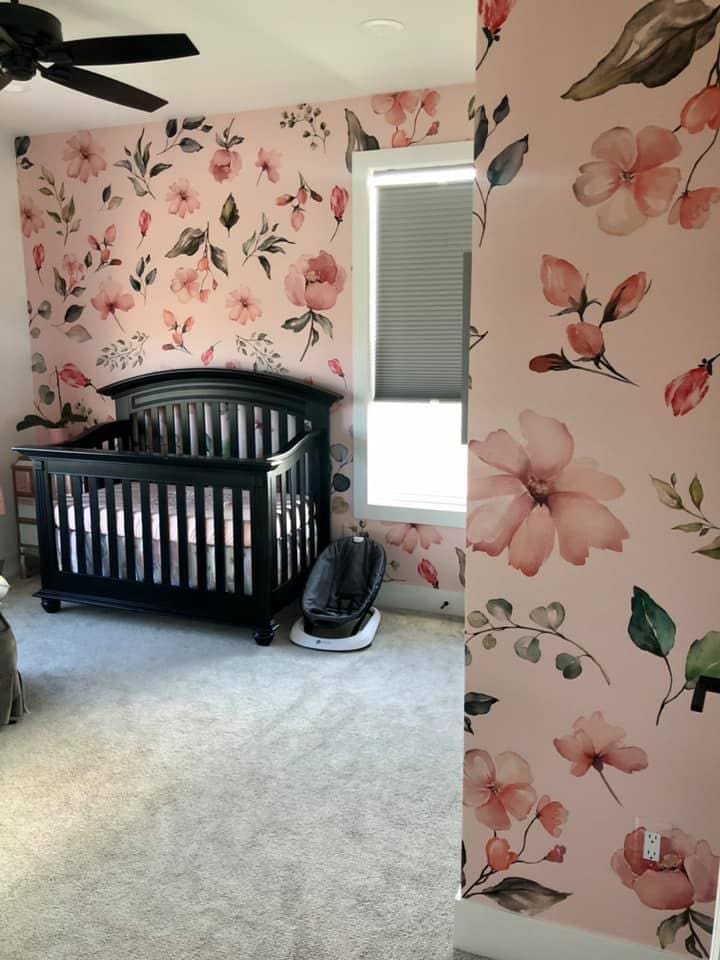 Baby nursey room with pink floral graphics as wallpaper