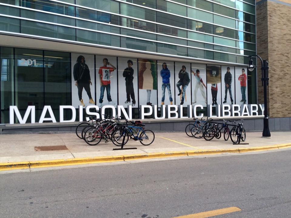 Glass film banner showing community members posing in Madison Public Library