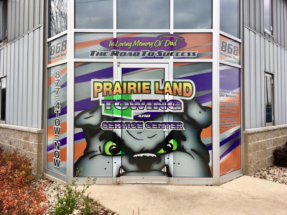 Prairie Land Towing and Service Center front of the building window graphics with bulldog and colorful design to attract curb appeal.