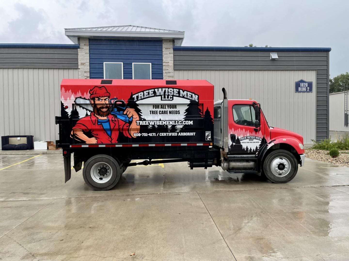 Tree wise men construction truck with fleet vehicle wrap graphic of cartoon lumberjack promoting the tree care business