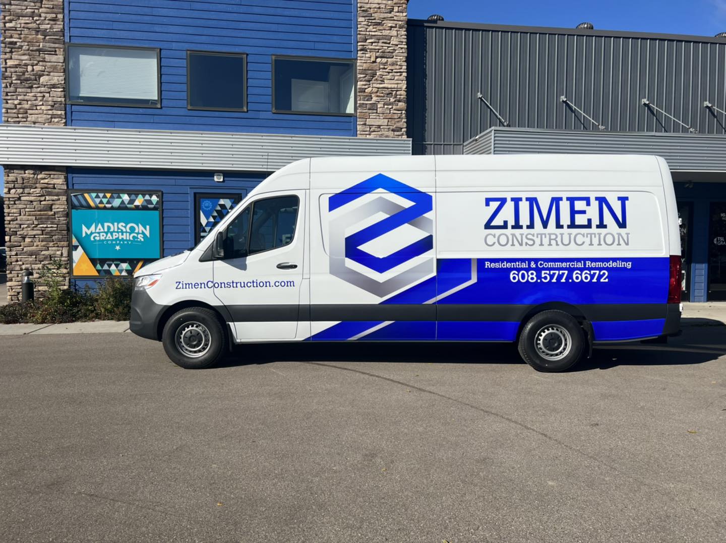 Zimen construction company van Patio pleasures van with Fleet Graphics Vehicle wrap designed by Madison Graphics Company parked in front of the design building