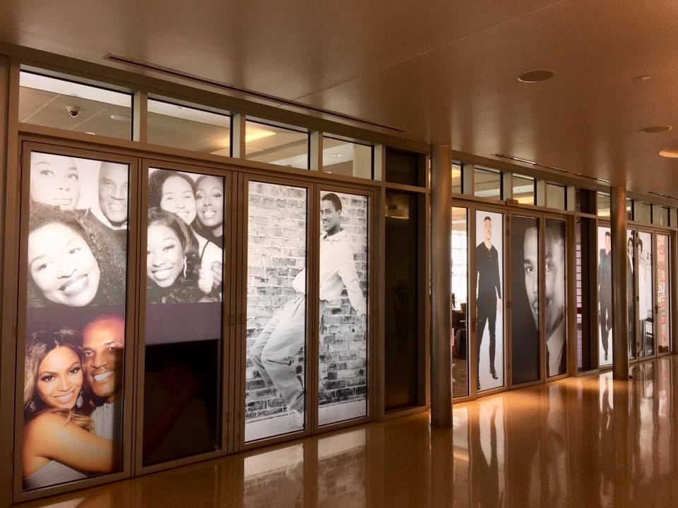 Glass film banner of people smiling. View is from the inside allowing the light shining through