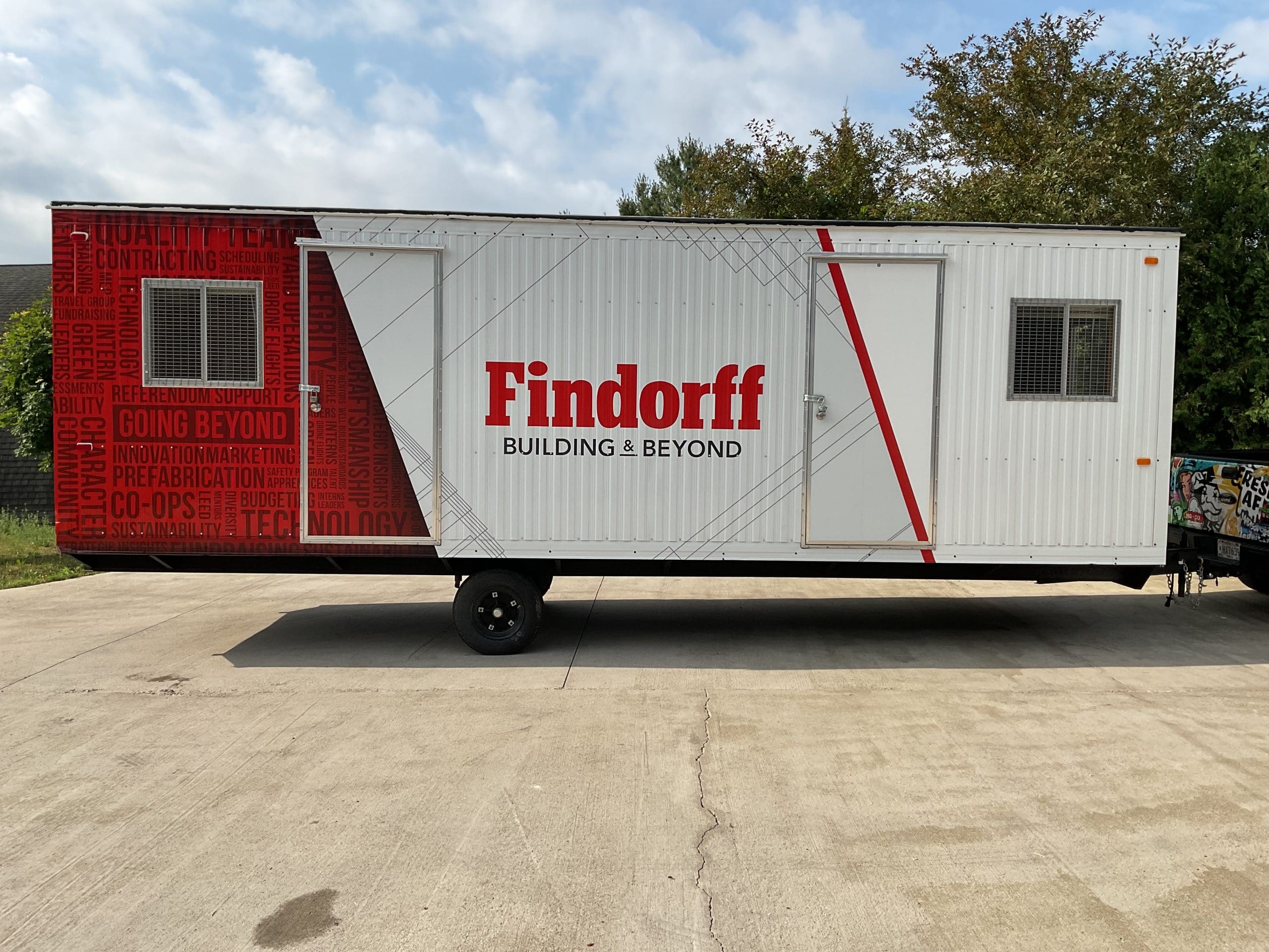 Findorff Building Beyond wrapped shipping container trailer hooked up to a truck