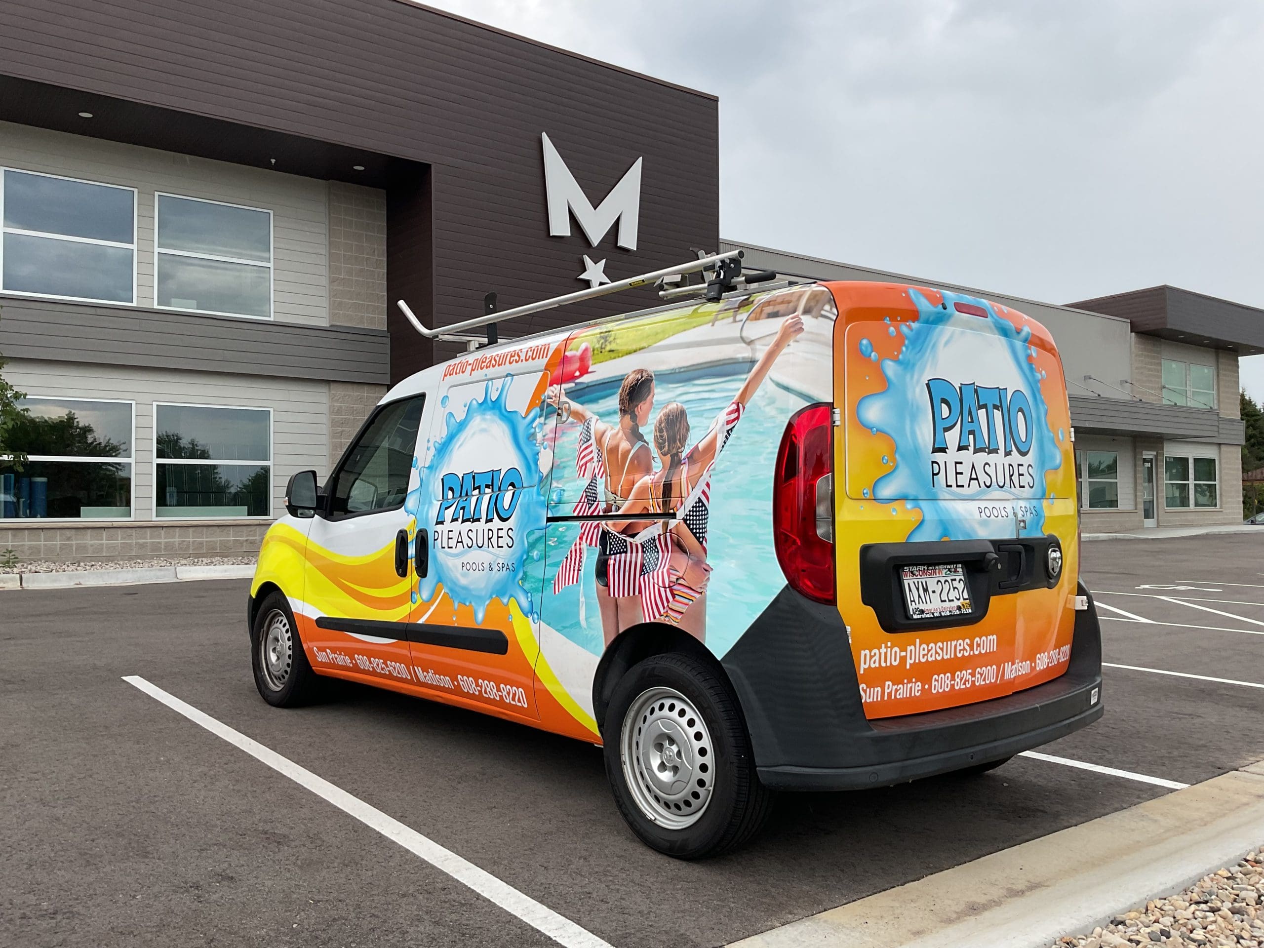 Patio pleasures van with Fleet Graphics Vehicle wrap designed by Madison Graphics Company parked in front of the design building
