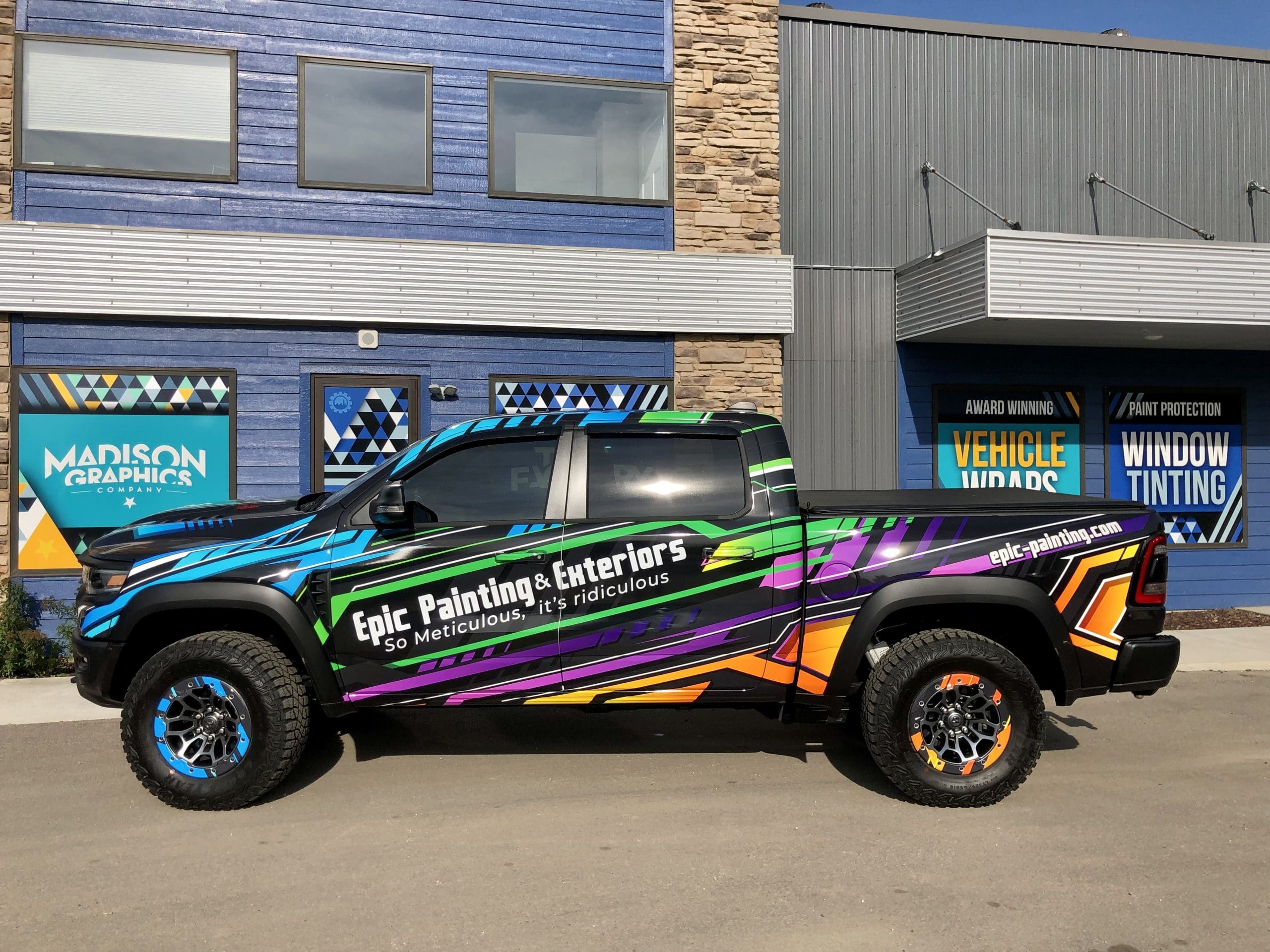 Epic painting & exteriors company truck with colorful Fleet Graphics Vehicle wrap parked in front of Madison Graphics Company