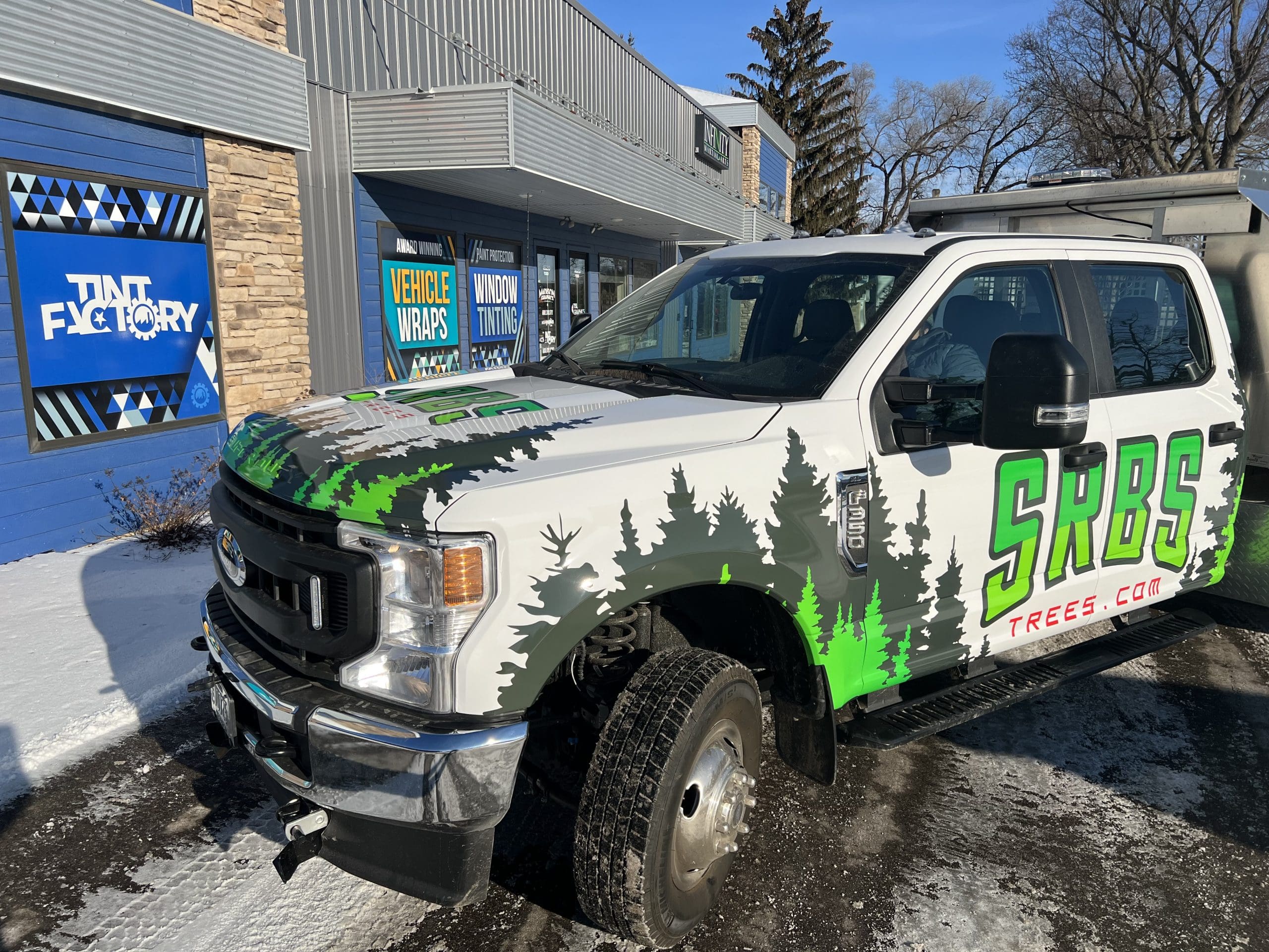 SRBS Truck with Fleet Graphics Vehicle wrap designed by Madison Graphics Company parked in front of the design building