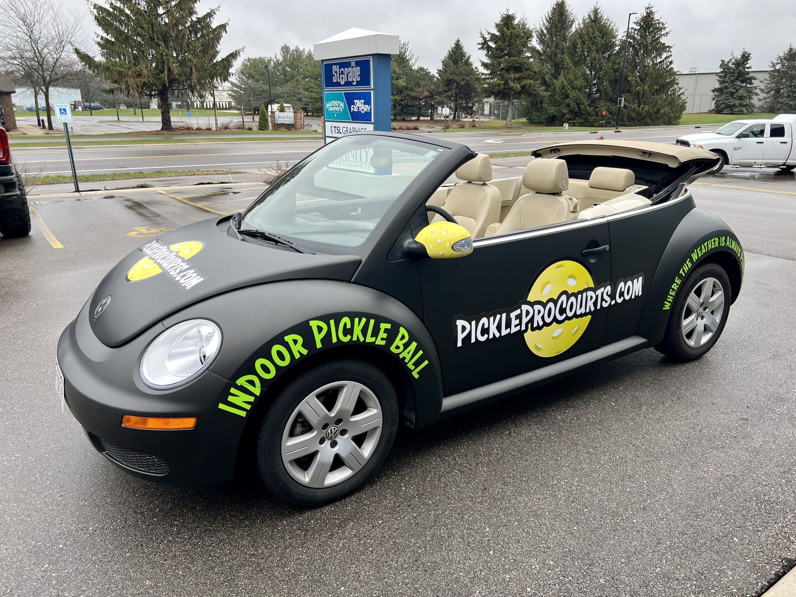Indoor pickle ball courts Volkswagen bug with vehicle prints on the side of the car.