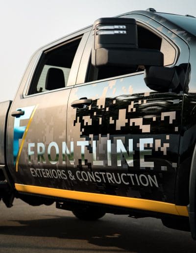 Truck with vehicle wrap promoting Frontline construction branding